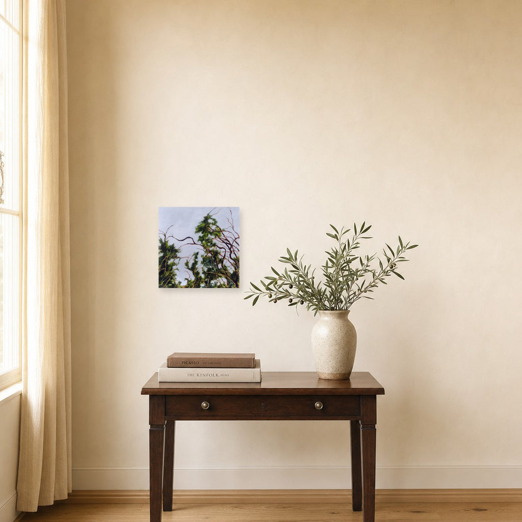Branches and Sky by Freya Grand shown to scale on a wall above a small wooden side table
