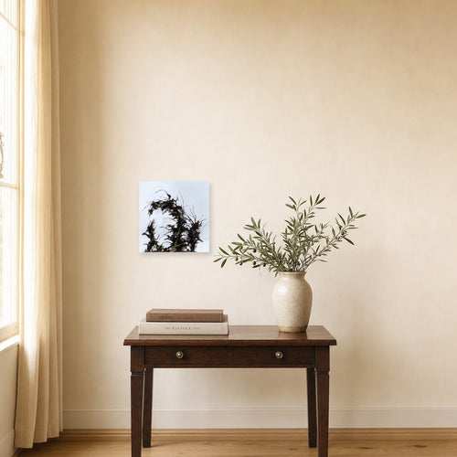 Branches and Sky II by Freya Grand shown to scale on a wall above a small wooden side table