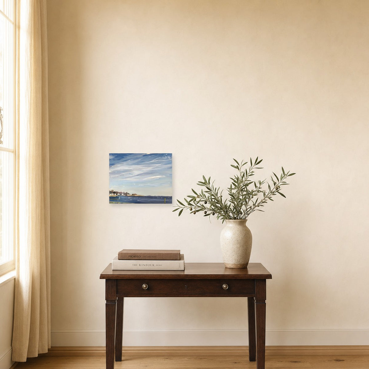 Coastal Breeze by Annie Wildey shown to scale on a wall above a small wooden side table