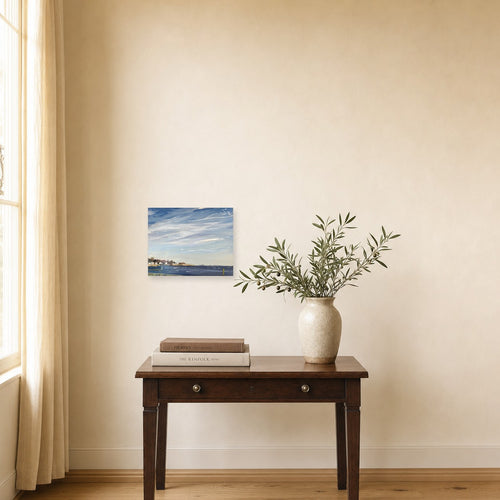 Coastal Breeze by Annie Wildey shown to scale on a wall above a small wooden side table