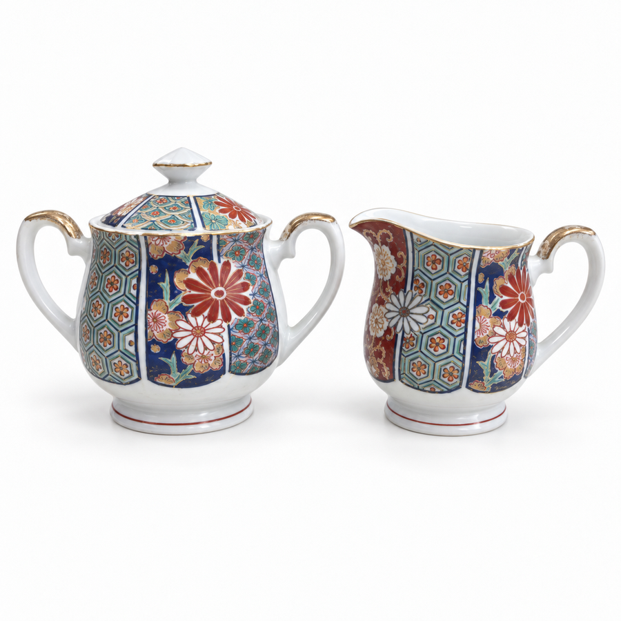 Arita Imari fan pattern lidded sugar bowl and creamer on a white background.