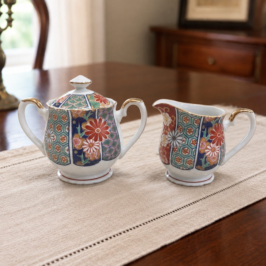Styled placement of the Arita Imari sugar bowl and creamer on an ivory linen runner.